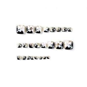 Short French toe press-on nails with white flowers, gold glitter and rhinestones