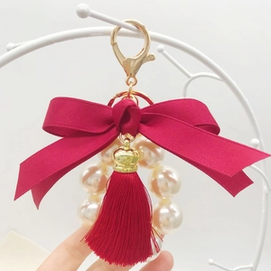 Chic keychain with red ribbon bow, large white imitation pearls and elegant long tassel