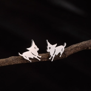 Polished stainless steel dog stud earrings in silver finish on natural wood