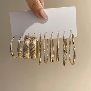 Set of six pairs of elegant gold hoop earrings in various textured styles on display card