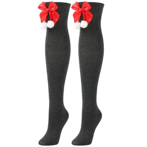 Close-up of over-knee Christmas socks in dark grey with red bows and white pom-poms