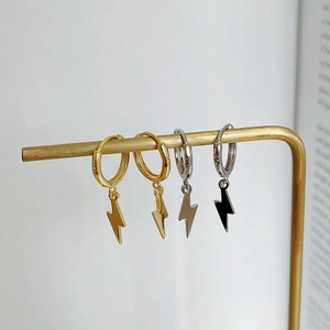 Close-up of gold and silver S925 sterling silver lightning bolt hoop earrings on a display