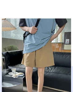 Detail of men's casual khaki shorts and blue-black patchwork t-shirt in a modern interior