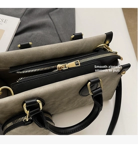 Gros plan sur la fermeture éclair dorée fluide et les coutures de ce sac cabas gris élégant