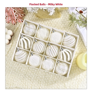 Set of 12 cream white flocked Christmas ornaments with assorted geometric textures in a box