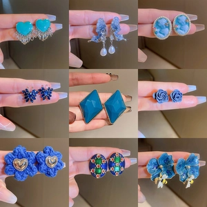 Detailed collection of nine blue vintage earrings with floral and heart-shaped designs