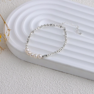 Detailed view of freshwater pearls on a silver geometric chain with extender