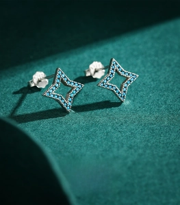 Macro shot of S925 sterling silver star stud earrings with blue pave zircon inlay