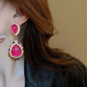 Detail view of retro pink teardrop earrings with crystals worn by a model