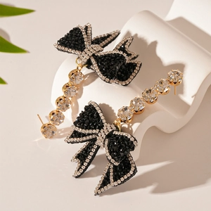 Close-up of black bow earrings with diamond rhinestones and elegant crystal tassels
