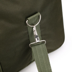Close-up of durable metal swivel hook and D-ring on a green fabric travel bag strap
