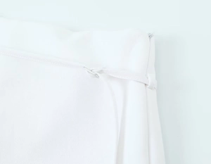 Detailed close-up of white woven culottes featuring side zipper and waist belt loops