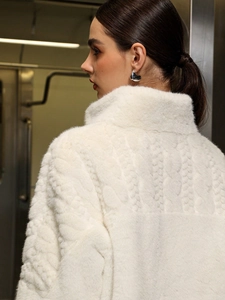 Macro shot of white faux fur coat featuring high collar and textured woven back details