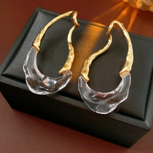 Detailed macro shot of 18k gold plated drop earring on a black textured jewelry box