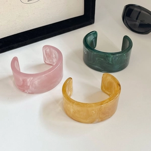 Detailansicht unregelmäßiger Acetat-Armreifen mit Marmormuster in Rosa, Grün und Bernstein