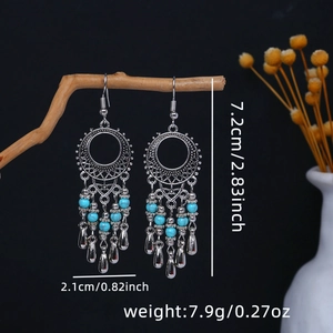 Macro view of vintage silver alloy tassel earrings with blue beads on dark wood