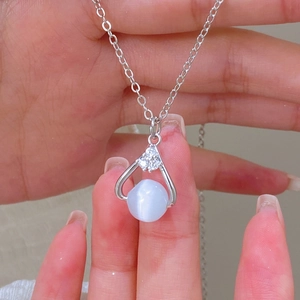 Macro shot of a silver teardrop pendant featuring a blue moonstone and zircon accents