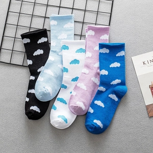 Five-color cotton crew socks with cloud pattern and ribbed cuffs on a textured surface