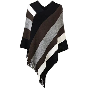 Close-up detail of knitted poncho with multi-color diagonal stripes and fringe tassels