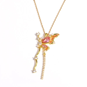 Gros plan détaillé d'un pendentif papillon doré avec des pierres roses et des perles fines