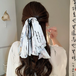 Detail of silk hair ribbon with Chinese calligraphy and pink floral patterns on model