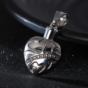 Macro shot of polished heart pendant with engraved hearts and black gemstone inlay