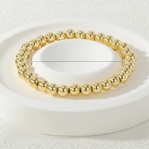Detail view of 18K gold plated elastic bead bracelet with 6mm polished beads