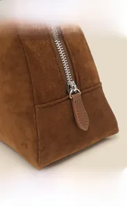 Detailed macro view of brown suede fabric texture with high-quality metal zipper and stitching