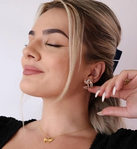Close-up of elegant gold butterfly earring and matching necklace set on model