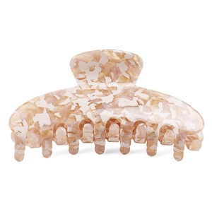 Detail of shark hair claw clip showing beige pink marble texture and acetate material