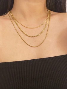 Close-up of a three-layer 18K gold plated snake and twisted chain necklace on neck