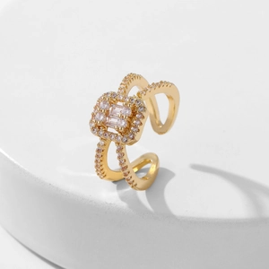 Golden square open ring with sparkling cubic zirconia on a minimalist marble background