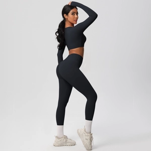 Close-up of black seamless long-sleeve crop top and high-waisted yoga leggings
