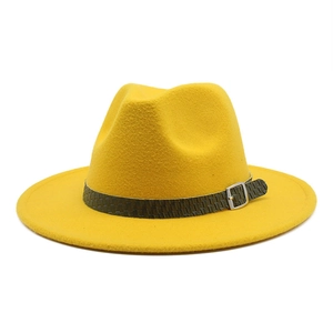 Dettaglio macro del cappello di lana giallo con nastro intrecciato verde e fibbia in argento