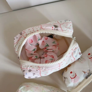 Detailed macro view of quilted floral cosmetic bag with cartoon print and matching scrunchie