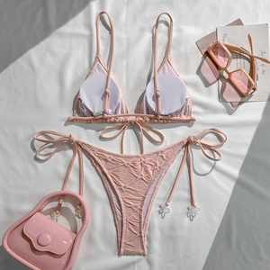 Detail of pink textured bikini with delicate 3D white flower charms on side ties