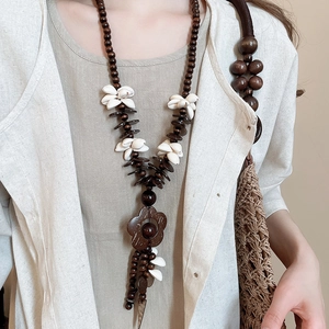 Detail of bohemian necklace with coconut shell wood beads and white shell floral pendant