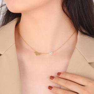 Gros plan d'un collier doré avec pendentif cœur porté sur le cou d'un mannequin