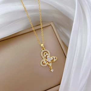 Macro shot of gold double-layer butterfly pendant with cubic zirconia on silk