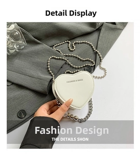 Close-up of white heart-shaped mini bag with elegant gold chain and pearl strap details