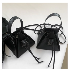 Detail of punk style PU leather triangular bags with cross and skull metal pendants