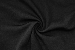 Close-up of soft black cotton blend fabric showing high-quality texture and spiral weave