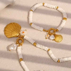 Détail de colliers et bracelets en coquillages dorés avec perles et breloques marguerites