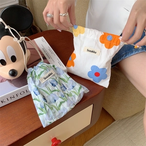 Close-up of portable cotton flower drawstring pouches for makeup storage and small items
