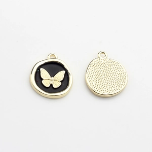 Detail of gold butterfly pendant with black enamel front and metallic textured back