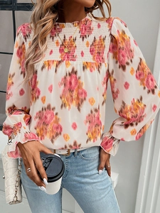 Detailed view of floral print blouse with shirred bust and elegant mock neck design