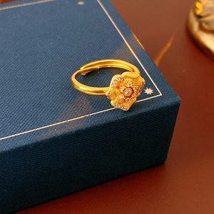 Macro detail of vintage gold flower ring with zircons on dark blue jewelry box