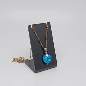 Detailed view of a blue heart crystal pendant hanging on a black acrylic L-shaped stand