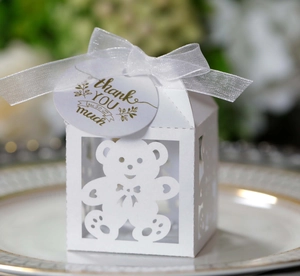 Detail of white laser-cut hollow bear candy box with ribbon and thank you tag