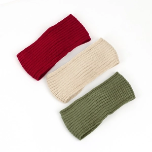 Detailed view of three warm ribbed knit headbands in red, beige and army green